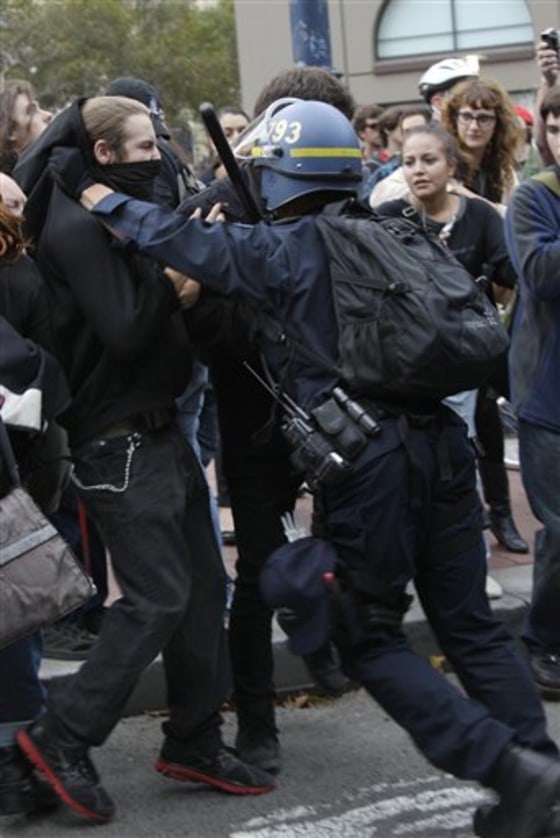 A San Francisco Police officer pushes protesters onto a sidewalk from Market Street in San Francisco, Monday, Aug. 22, 2011. About 100 demonstrators on Monday were protesting the Bay Area Rapid Transit agency's decision to cut wireless service in its San Francisco stations earlier this month.